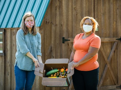 Women with box of vegetables