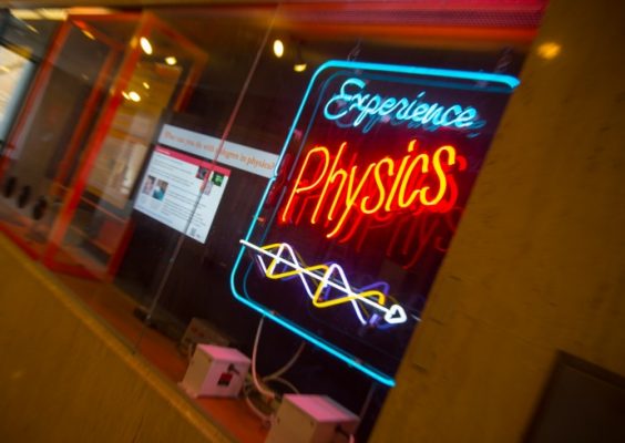 neon sign that says Experience Physics located near Physics Lab