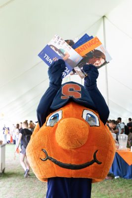 Otto holding Syracuse Abroad pamphlets at Syracuse Abroad Day in Fall 2019