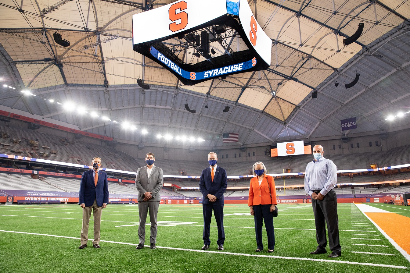 John Wildhack, director of Athletics; Syracuse Mayor Ben Walsh; Chancellor Kent Syverud; Ruth Chen, professor of practice in the College of Engineering and Computer Science; Pete Sala, chief facilities officer pose inside the renovated Stadium