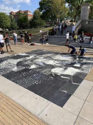 students surround a mosaic of drawings on the Einhorn Family Walk