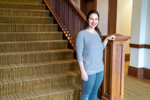 Sarah Workman, director of proposal development, poses near a staircase in the Tolley Humanities Building