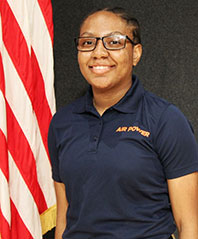 Divyne Hutchinson posing in front of the U.S. flag