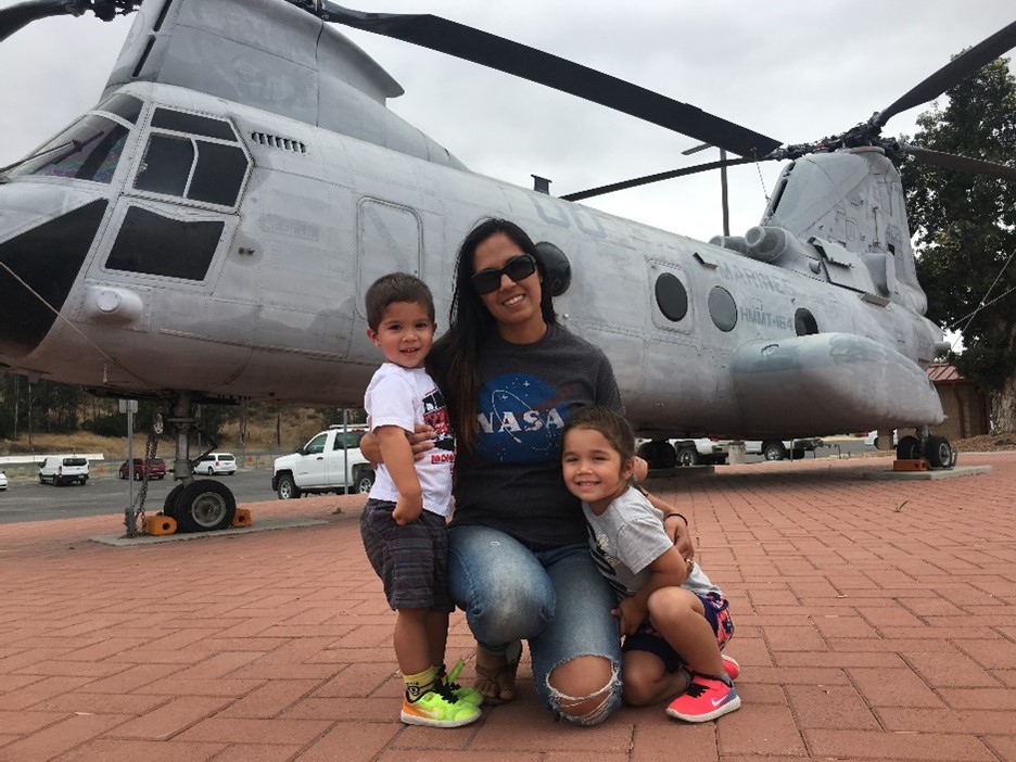 person with two children in front of helicopter
