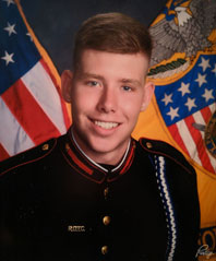 Kyle Huff in uniform posing in front of US flags