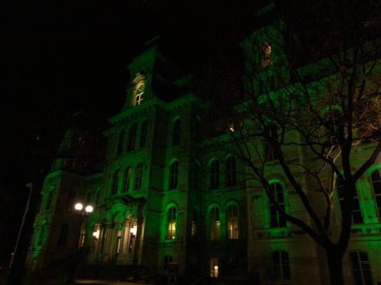 Hall of Languages lit up in green at night