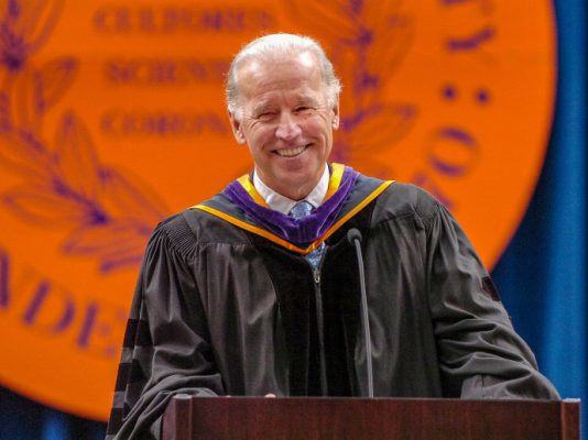 Joe Biden at podium in front of Syracuse University seal