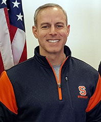 Scott Deutsch posing in front of an American flag