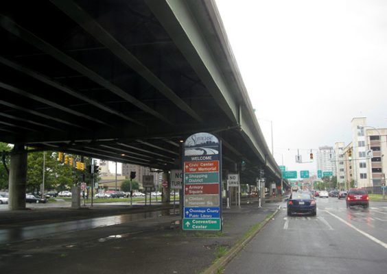 cars traveling under highway bridge