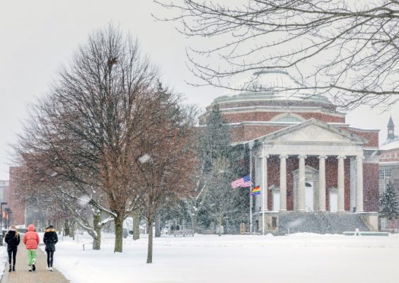 people walking across a snowy campus