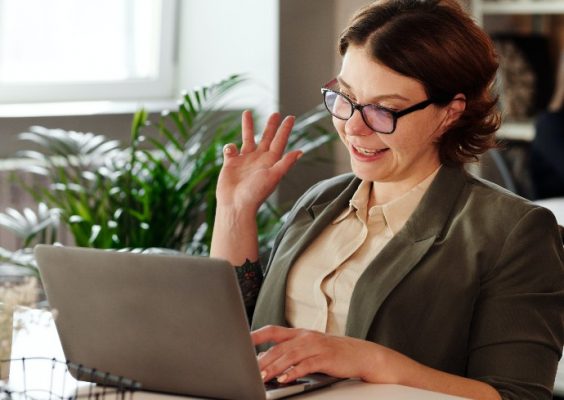 stock image of someone waving to her computer screen