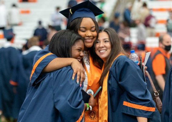 three friends hugging during Commencement 2021