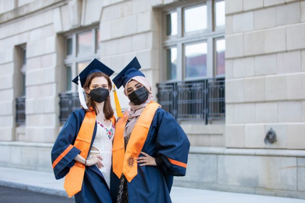 two students posing together in their caps and gowns