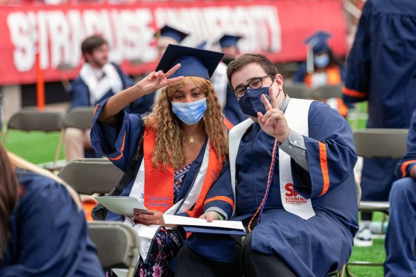 two students hold up peace fingers at Commencement 2021