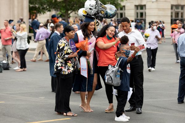 a graduate and their family celebrating and taking photos outside