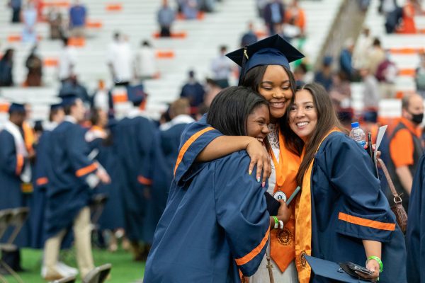 three students hug closely at Commencement 2021