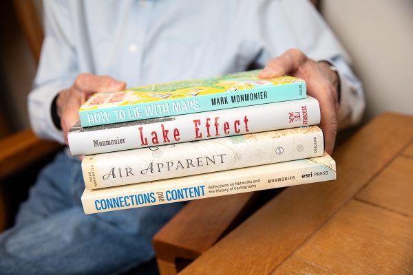 person holding four books