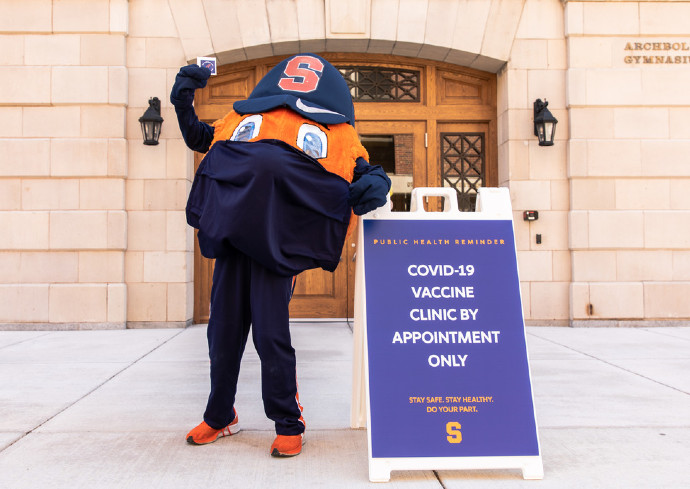 Otto standing outside building next to a sign