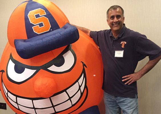 person standing next to inflatable of Otto the Orange