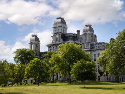 The Hall of Languages rises above the trees on a summer day