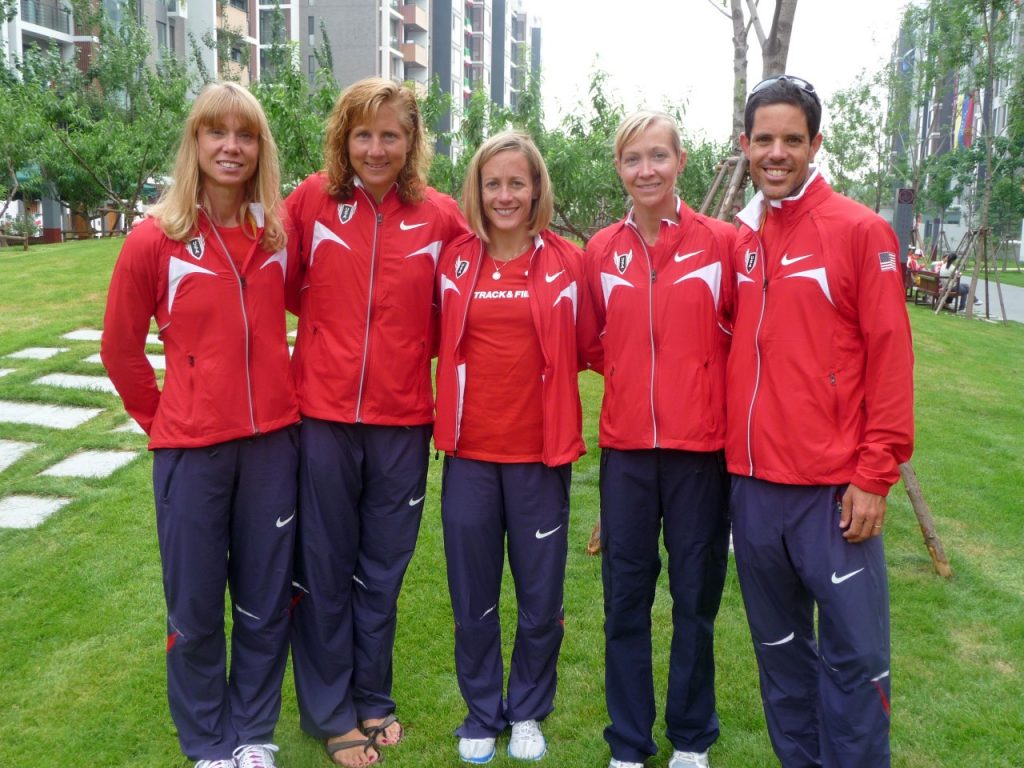Kimberly Keenan-Kirkpatrick poses with four distance runners