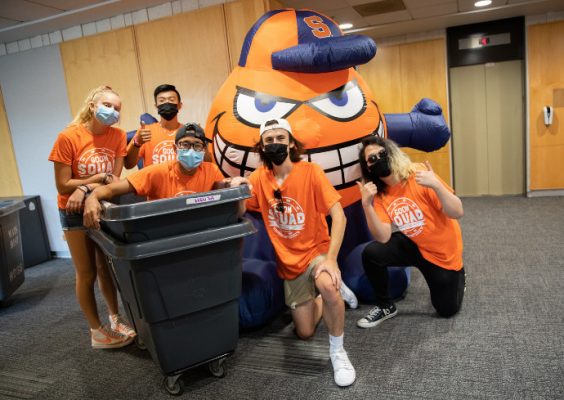 students pose with move-in bins with inflatable Otto the Orange