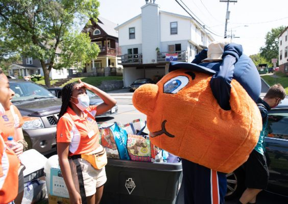 people standing next to move-in bins with Otto the Orange