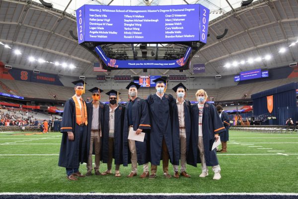a group of seven participants in Commencement 2020 on the field of the stadium