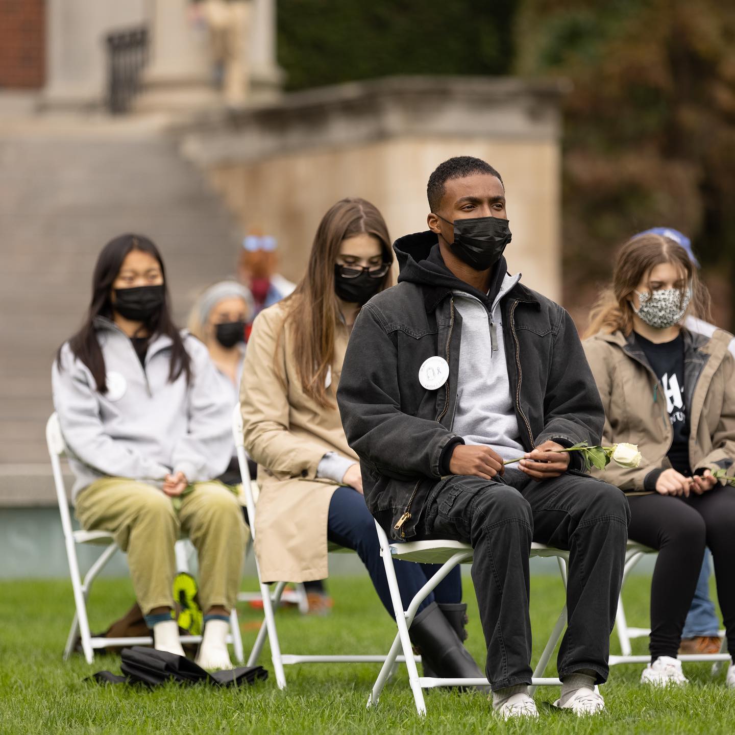 people wearing masks sitting on chairs on Quad