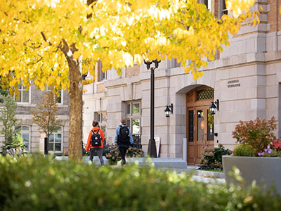 students walking past campus building