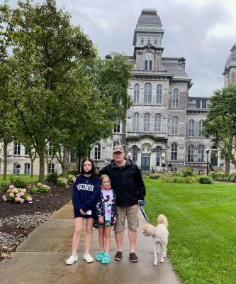 John Burse, his dog, and two daughters in front of the Hall of Languages