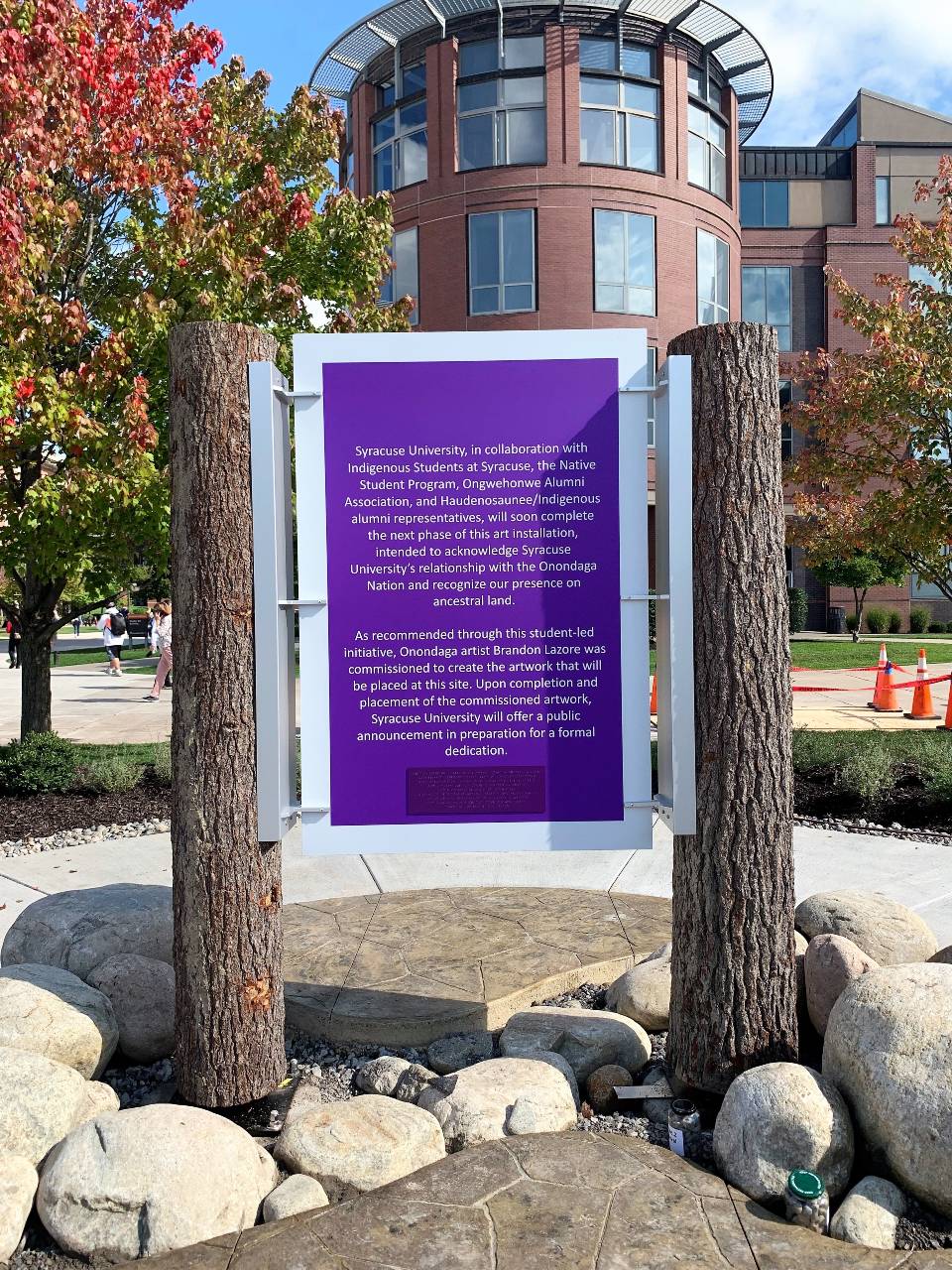 a purple sign explaining the new Onondaga Art Installation on the quad