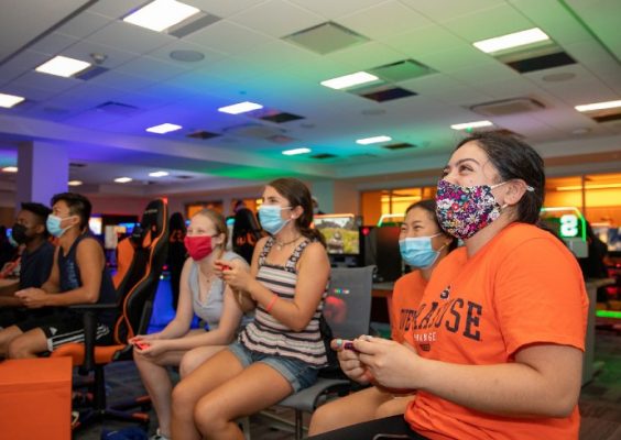 students wearing masks and playing games in the Esports room