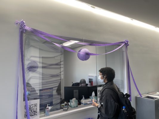person standing at welcome desk with purple decorations