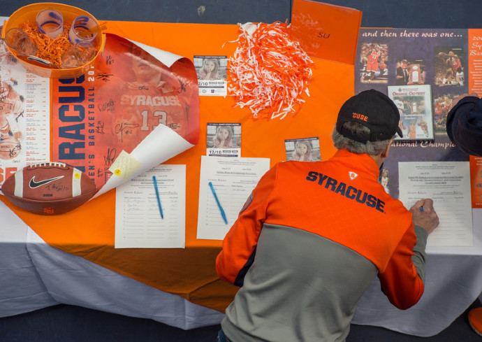 person standing in front of table filled with sports items up for auction