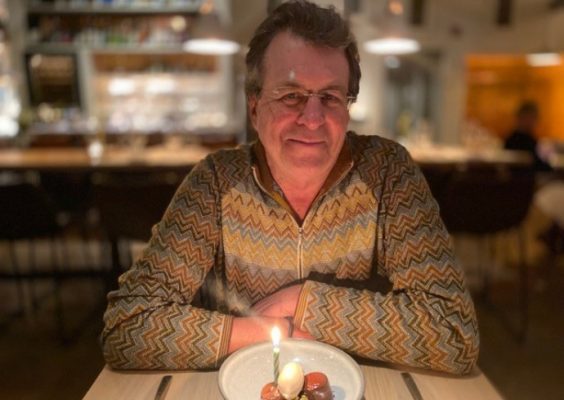 person sitting at table in front of plate of food with candle in it
