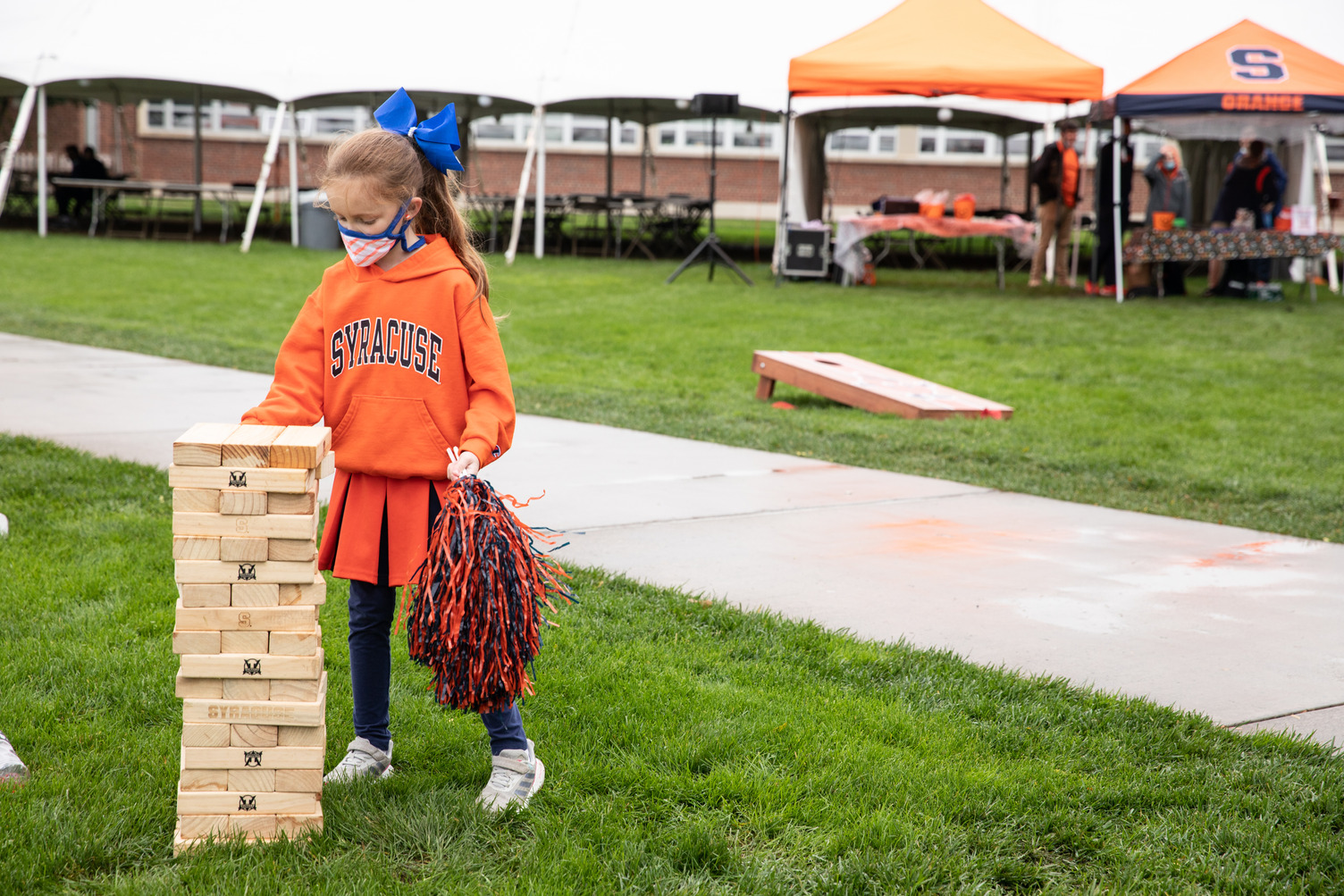 child plays a game of Jenga on the Quad during Orange Central tailgate celebration