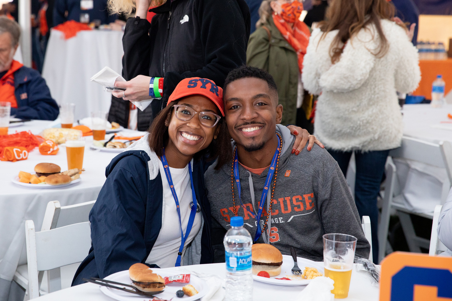 two people posing together during a meal at the Orange Central tailgate celebration