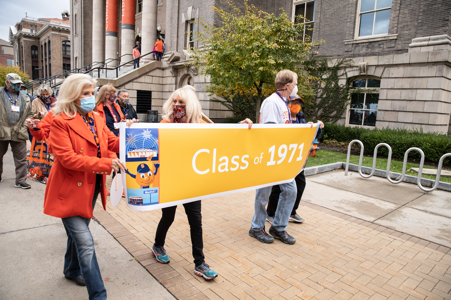 three people holding a Class of 1971 banner at the 2021 Orange Central tailgate celebration