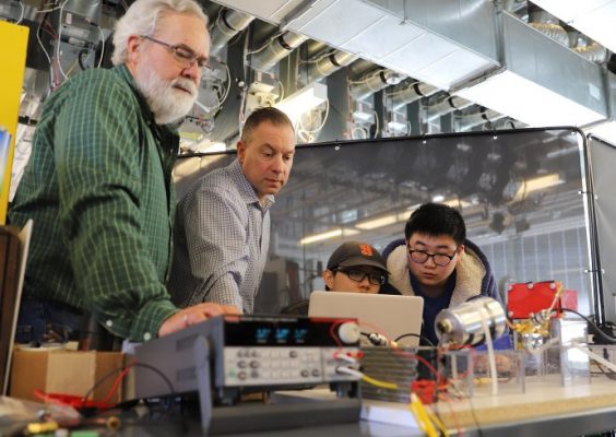 students and faculty members collaborate in a research lab
