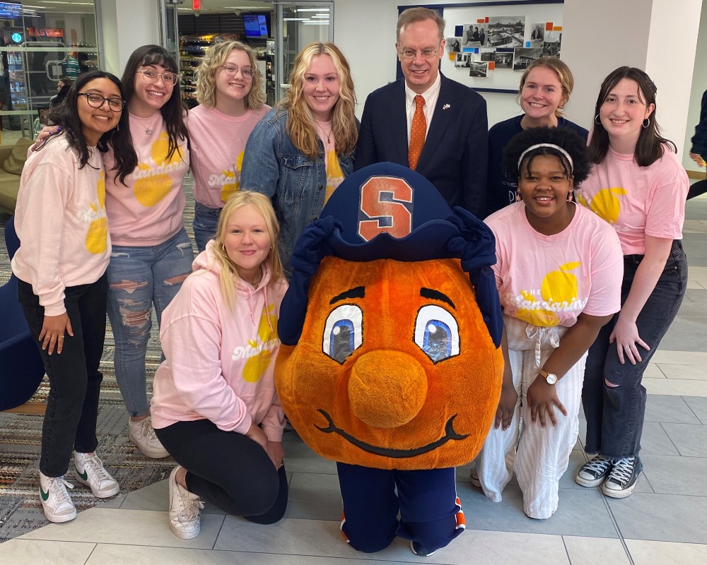 Chancellor Syverud poses with Otto and members of the Mandarins a capella group during the 2022 National Orange Day Celebration