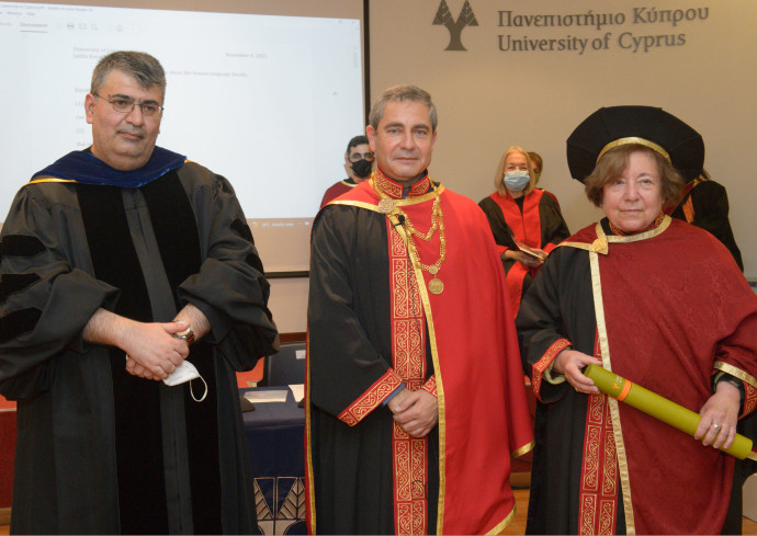 three poeple standing in commencement robes