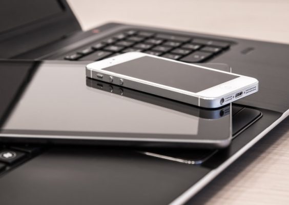 phone resting on a tablet resting on a computer laptop