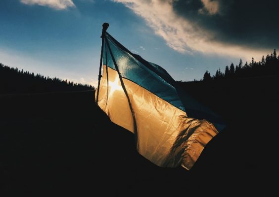 Ukrainian flag flies over a backdrop of hills and blue sky