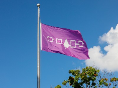 Haudenosaunee flag flying on the backdrop of blue sky