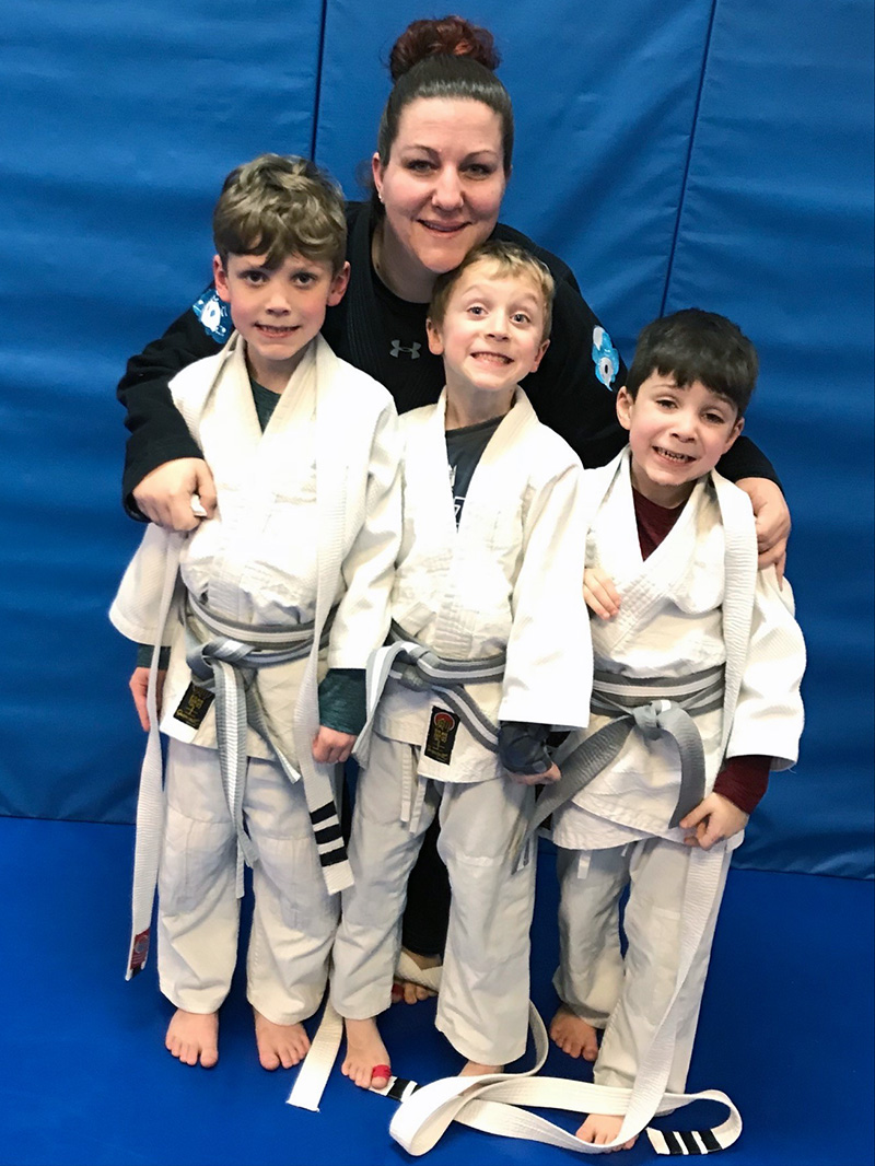 Amanda Lalonde '23 poses with her three sons, Tyler, Noah and Jack at a martial arts event