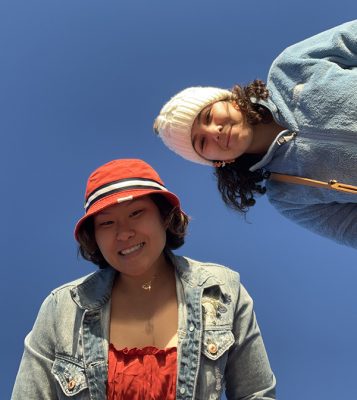Sara Lim and a friend pose for a picture with blue sky behind them