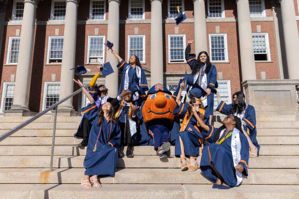 graduates standing on steps in graduation caps and gownswith Otto