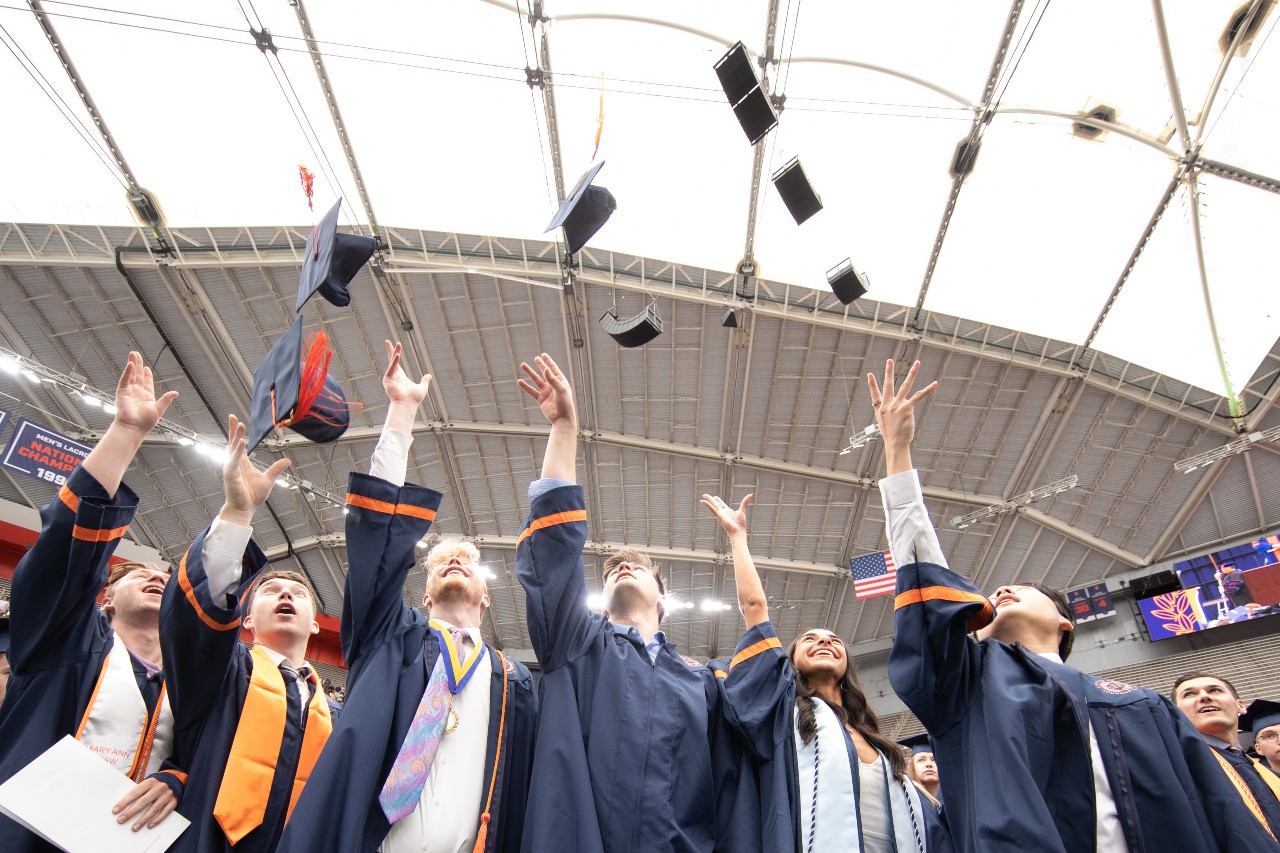 Students tossing graduation cap