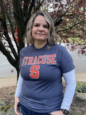 Tehnaya Brewer's mom, Patricia, in a Syracuse t-shirt posing in front of a tree